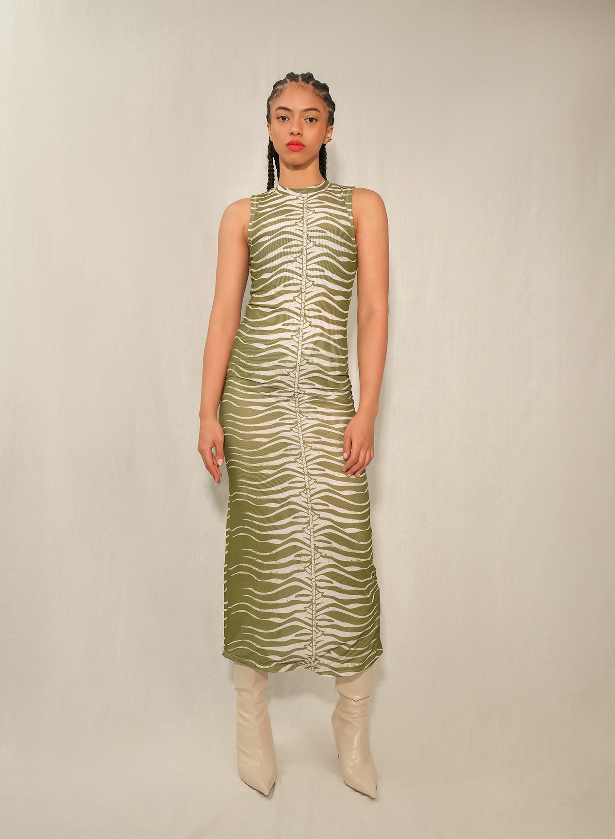 Model wearing sleeveless mesh column midi dress in Green Snake print with back slit.