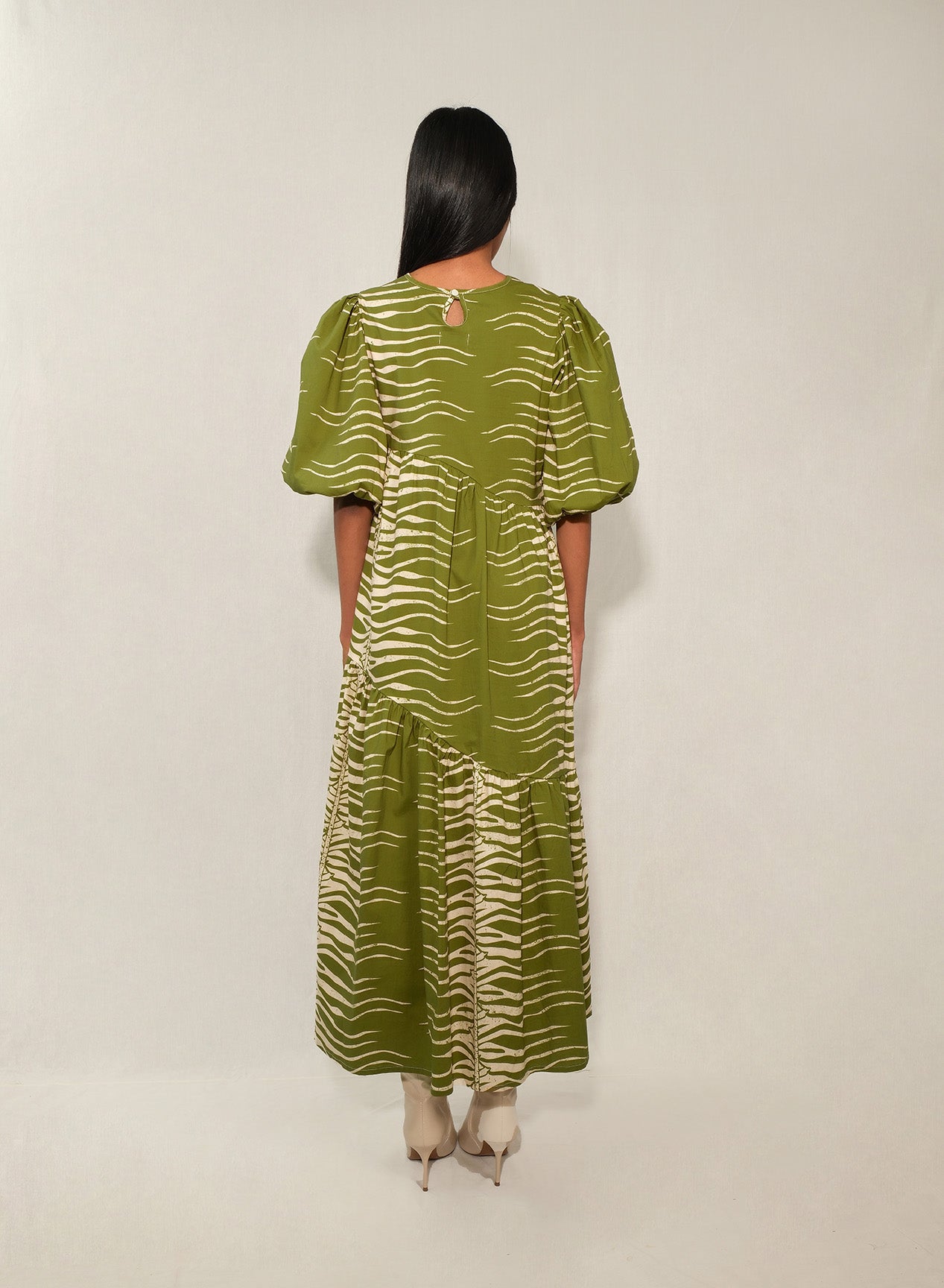Model wearing puff sleeve tiered midi dress in Green Snake print.