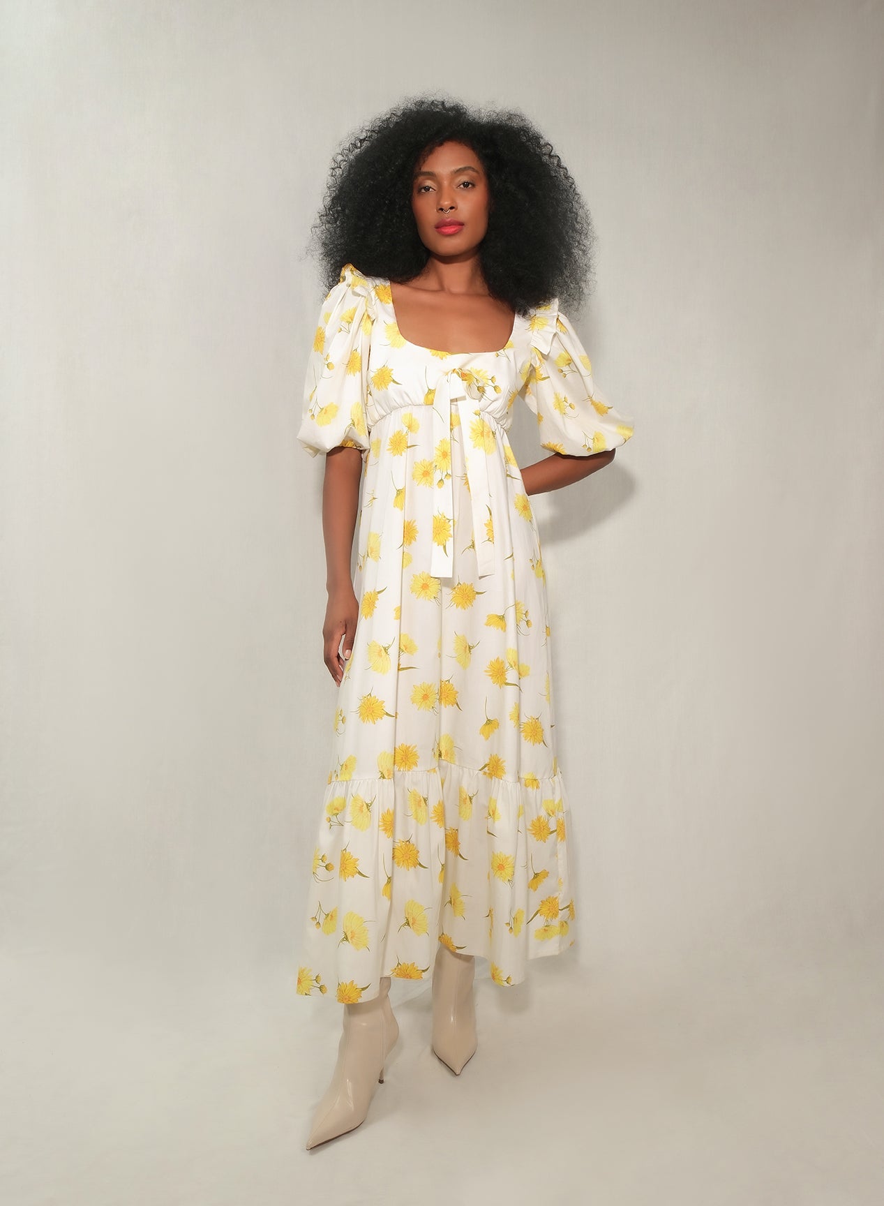 Model in floral puff-sleeve bow-front maxi dress with tiered skirt in yellow daisy print.