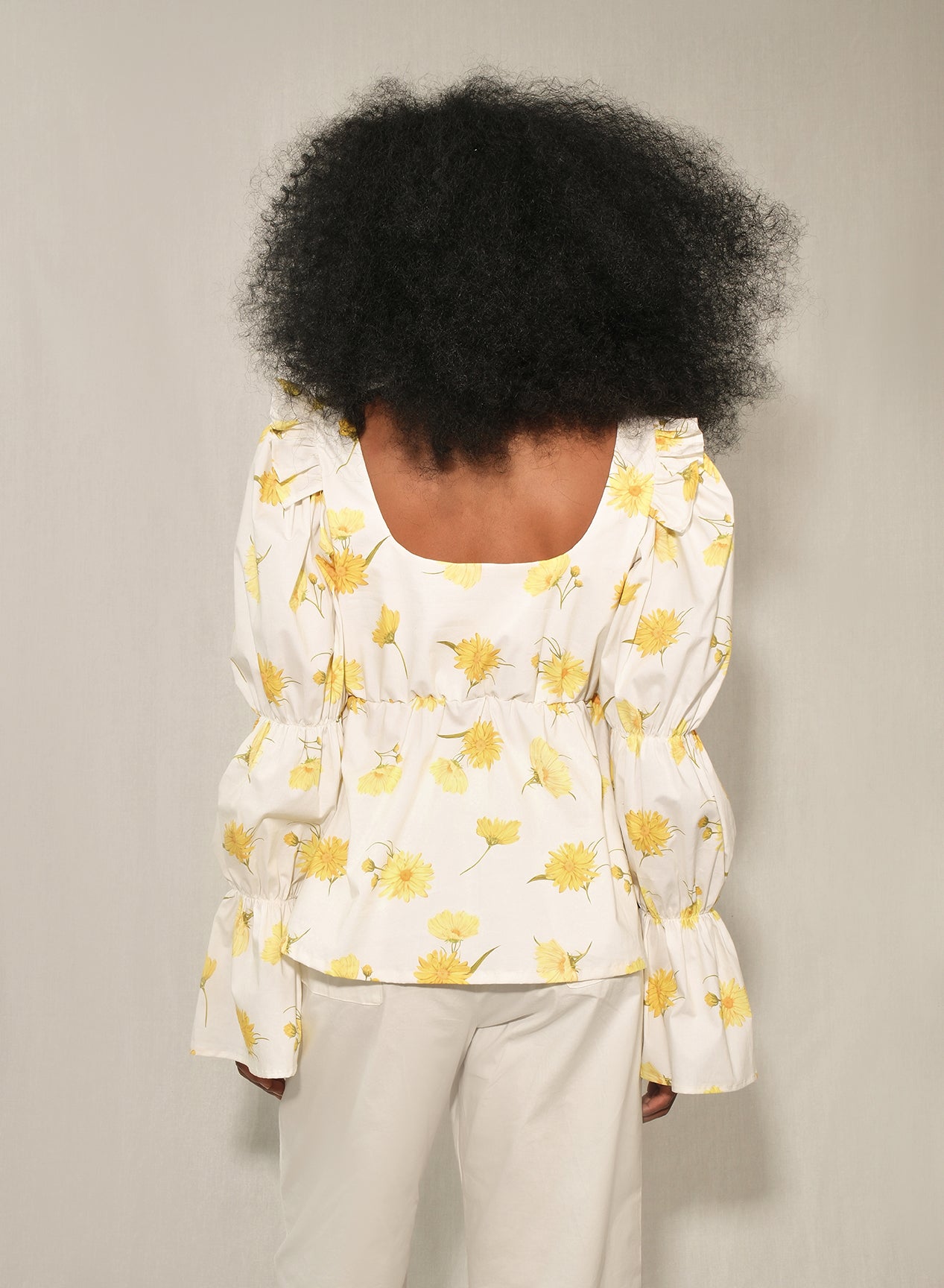 Model wearing women’s puff sleeve poplin top with tie-front keyhole in Maxi Daisy print