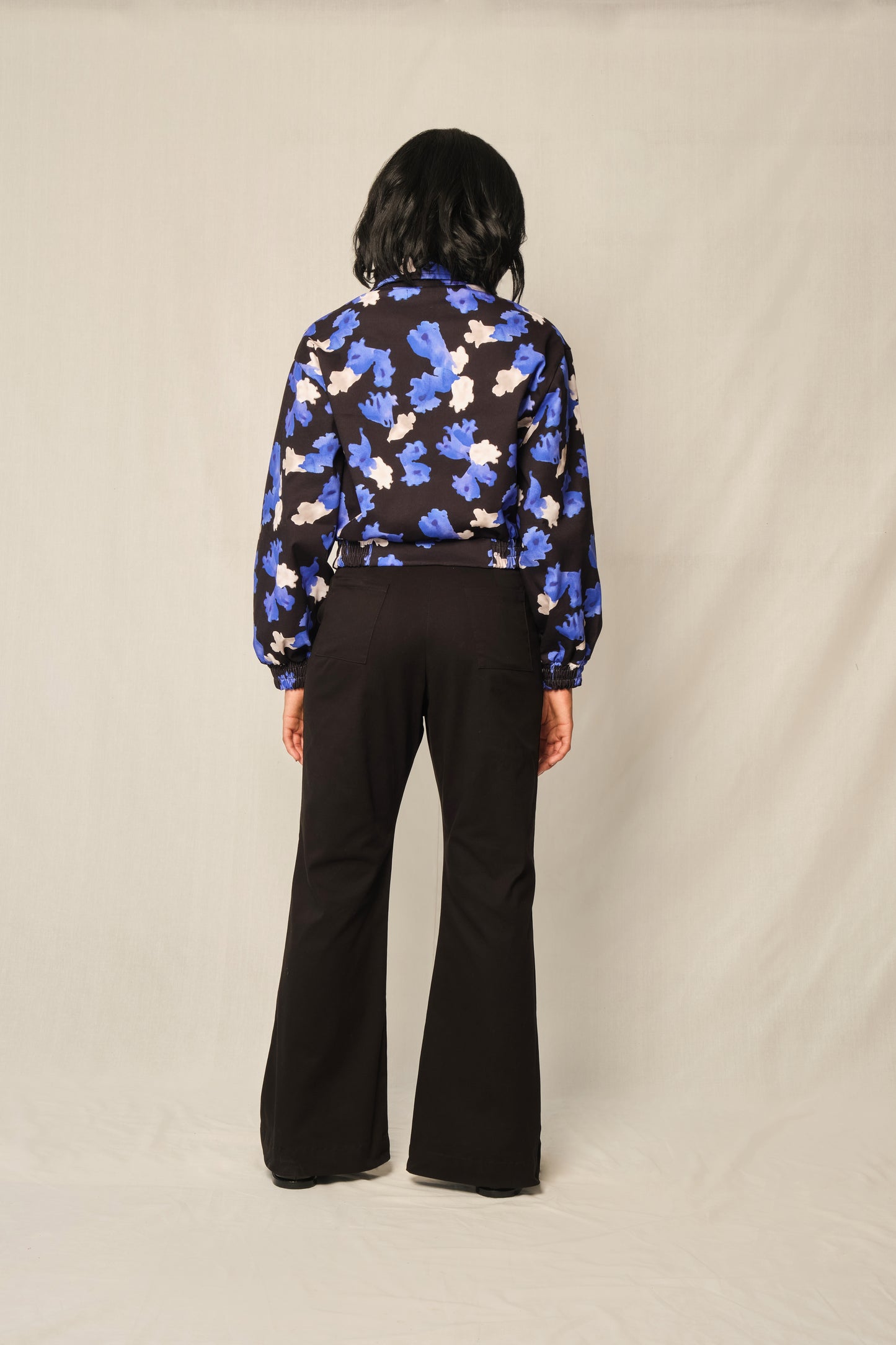 Cropped cotton bomber jacket in Jacaranda Blue print with rounded collar and balloon sleeves.