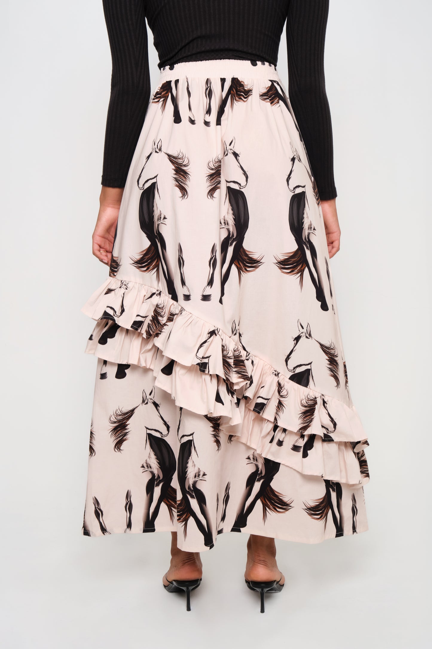 Model wearing asymmetrical ruffle maxi skirt with beige horse print