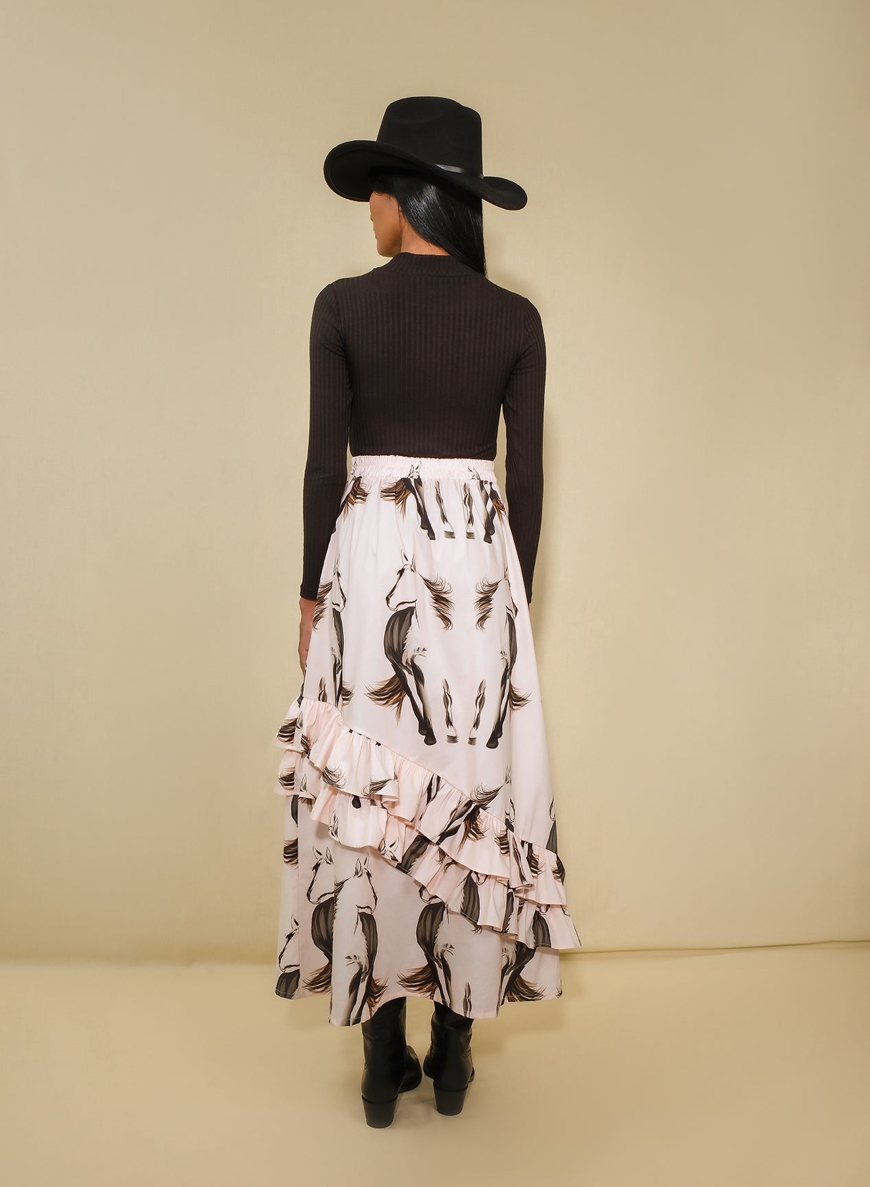 Model wearing asymmetrical ruffle maxi skirt with beige horse print