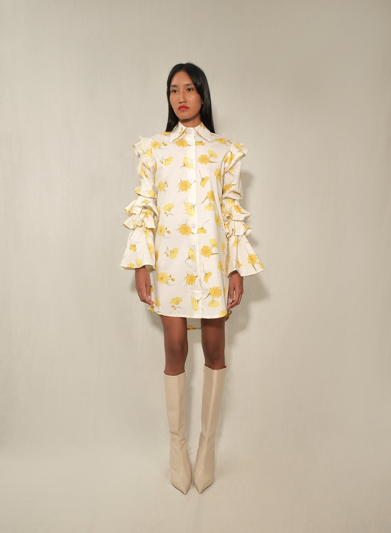 Model in ruffle-sleeve floral shirt dress in yellow daisy print, mini length.