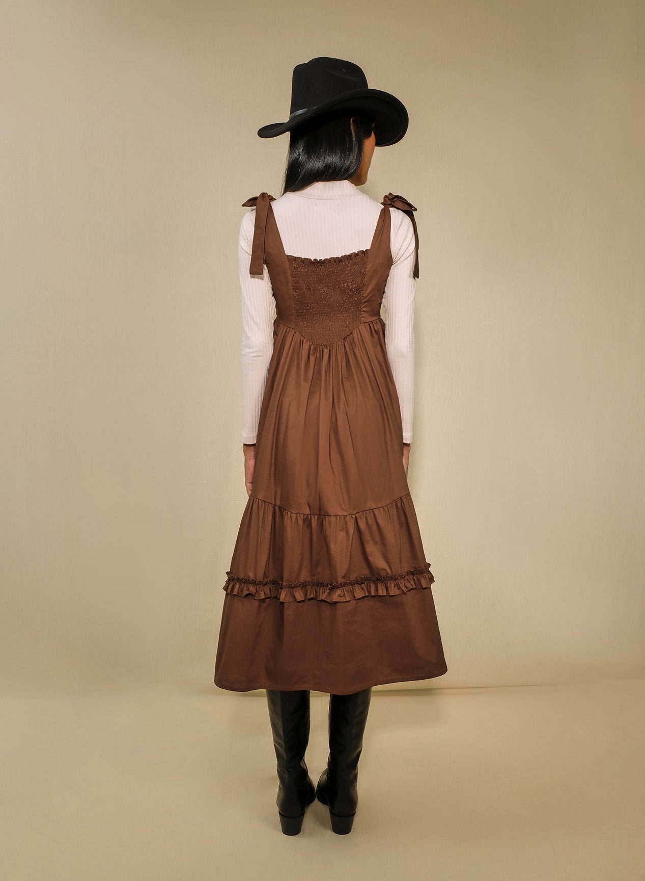 Model in fit-and-flare poplin midi dress with corset bodice, adjustable ties, and tiered ruffle skirt.