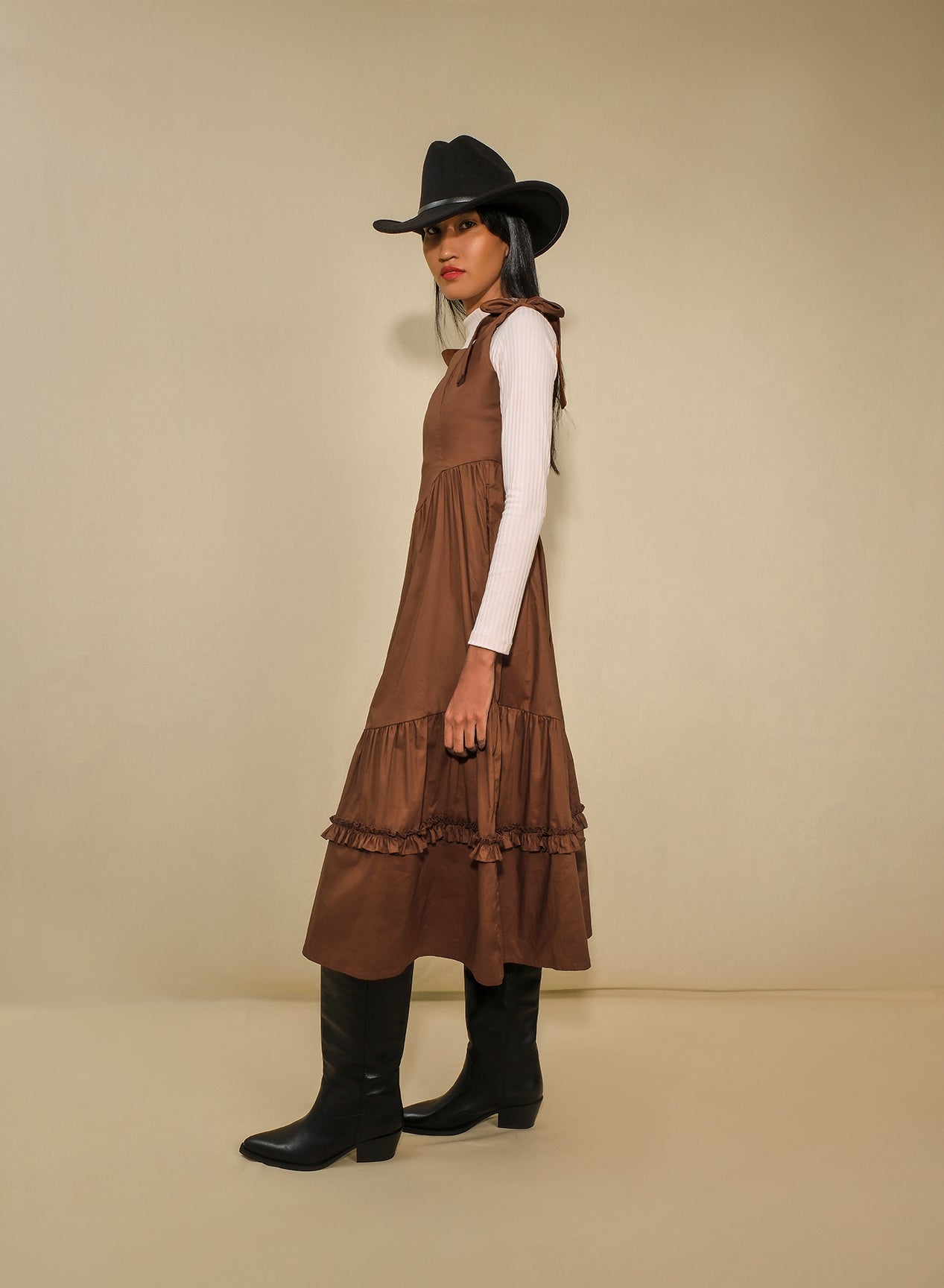 Model in fit-and-flare poplin midi dress with corset bodice, adjustable ties, and tiered ruffle skirt.
