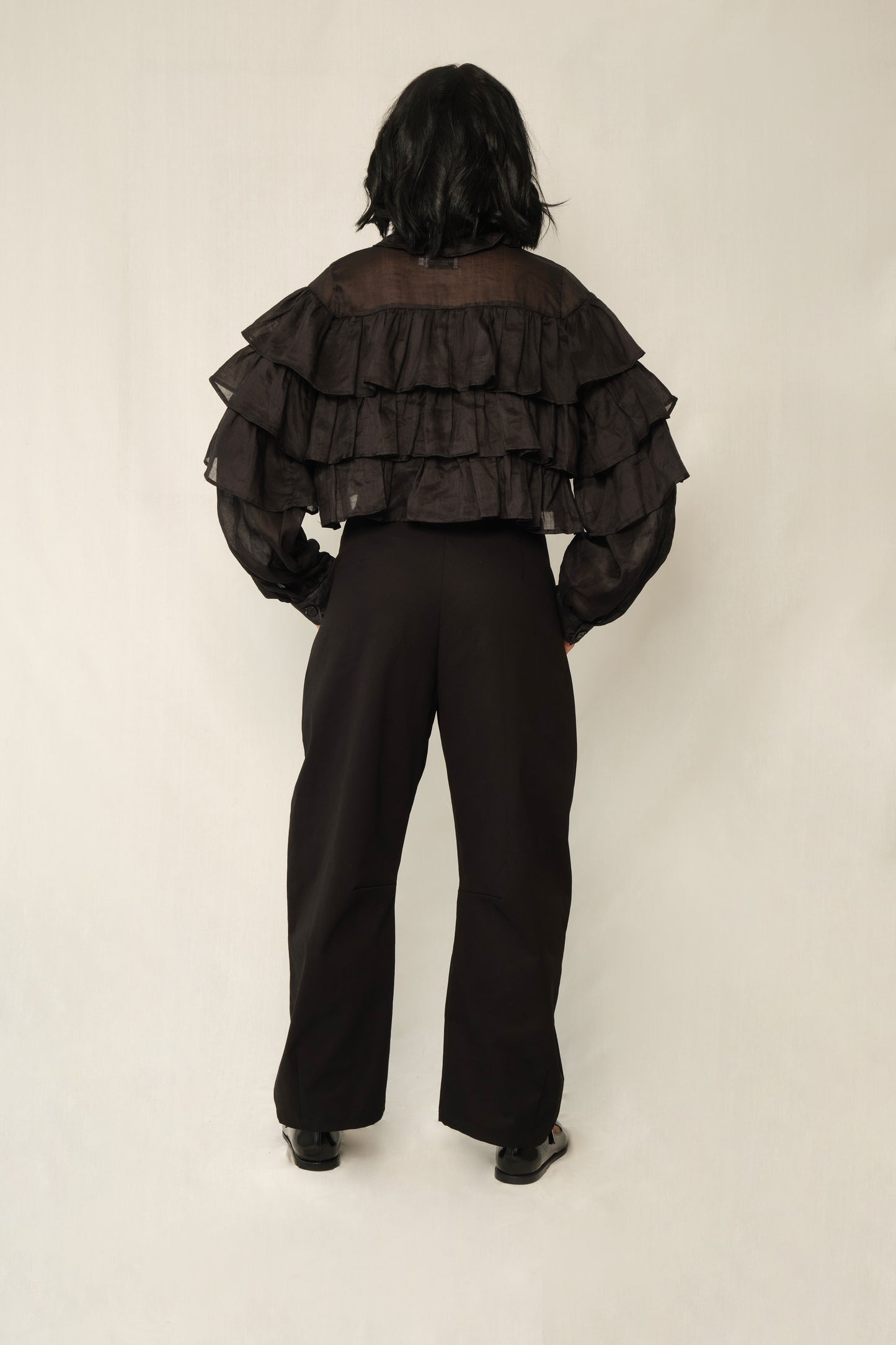 Black lightweight linen ruffle blouse with button front, tiered ruffles, and balloon sleeves.