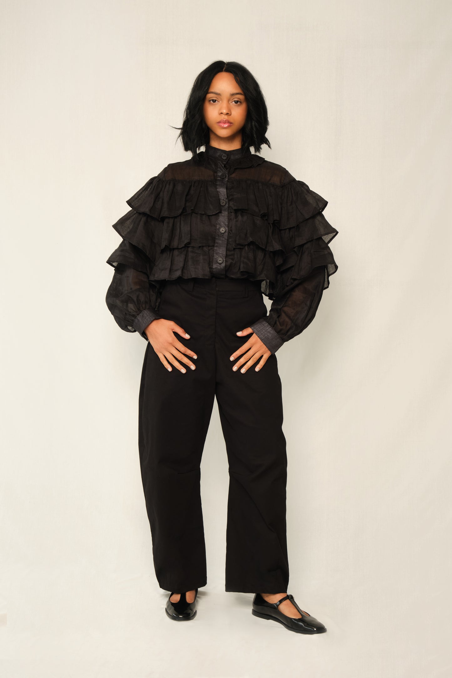 Black lightweight linen ruffle blouse with button front, tiered ruffles, and balloon sleeves.