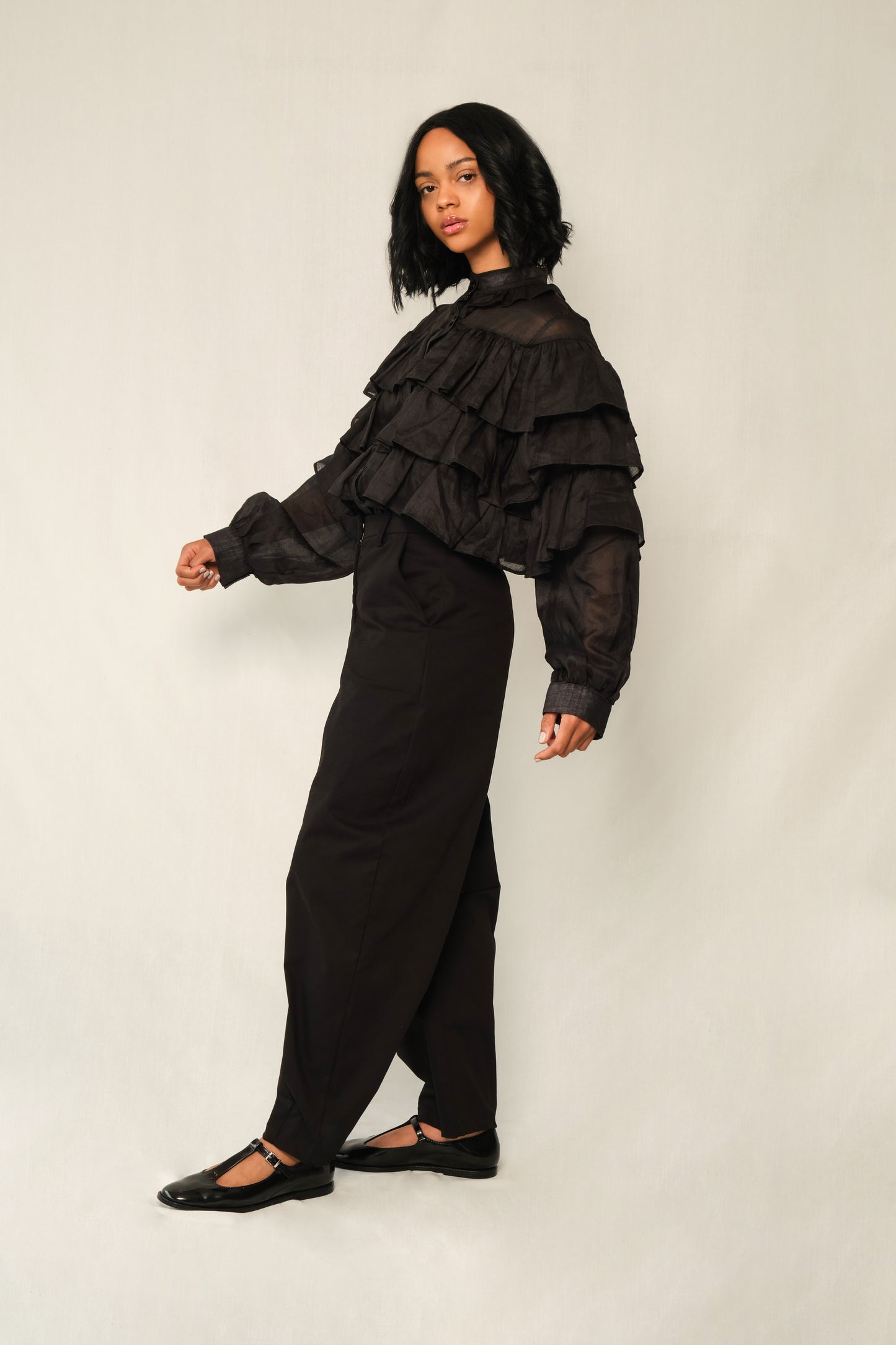 Black lightweight linen ruffle blouse with button front, tiered ruffles, and balloon sleeves.
