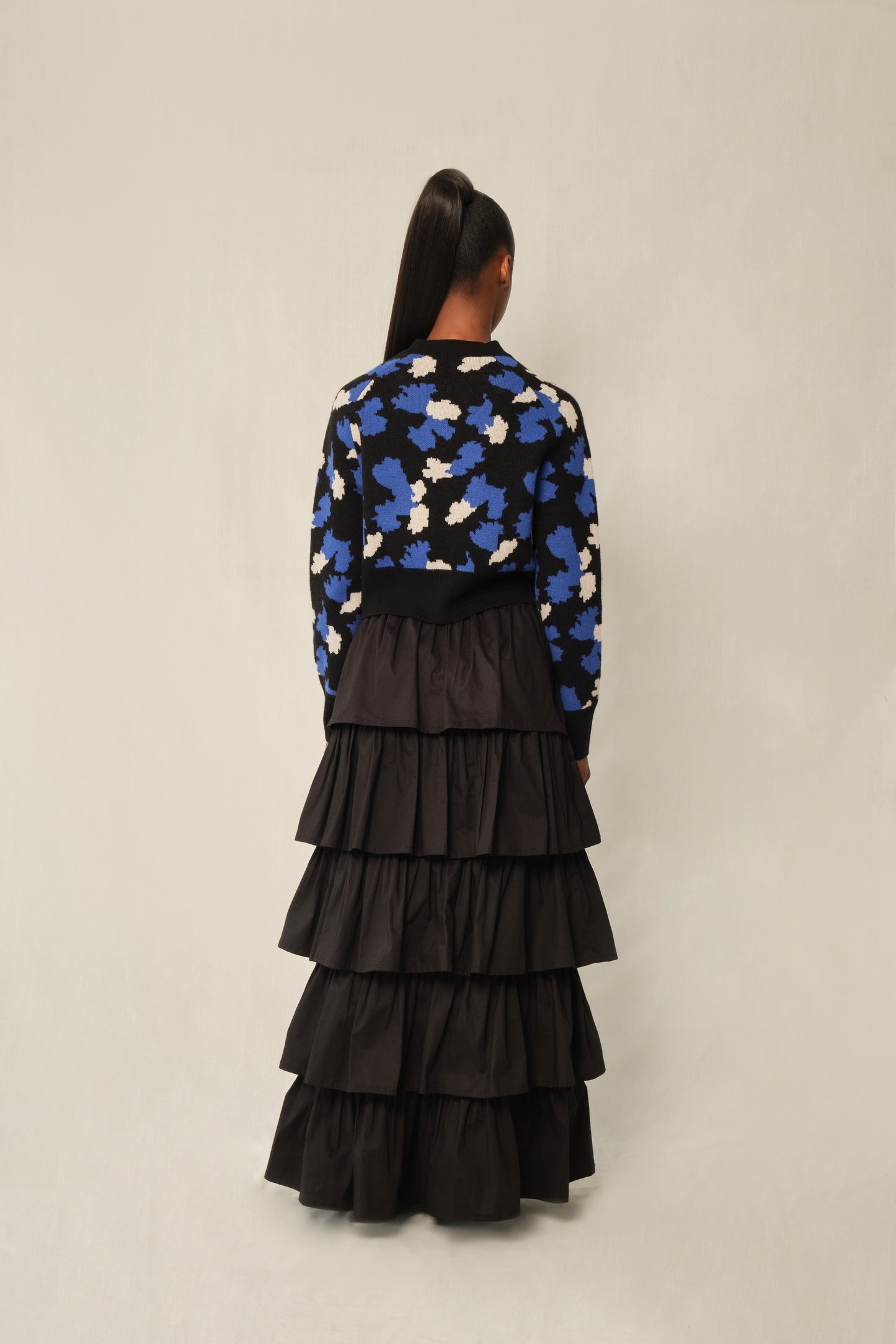 Model wearing black tiered maxi skirt in stretch poplin with elastic back waistband.