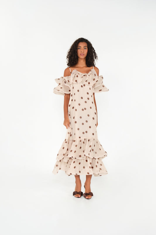 Woman wearing a polka dot dress with ruffled sleeves on a white background