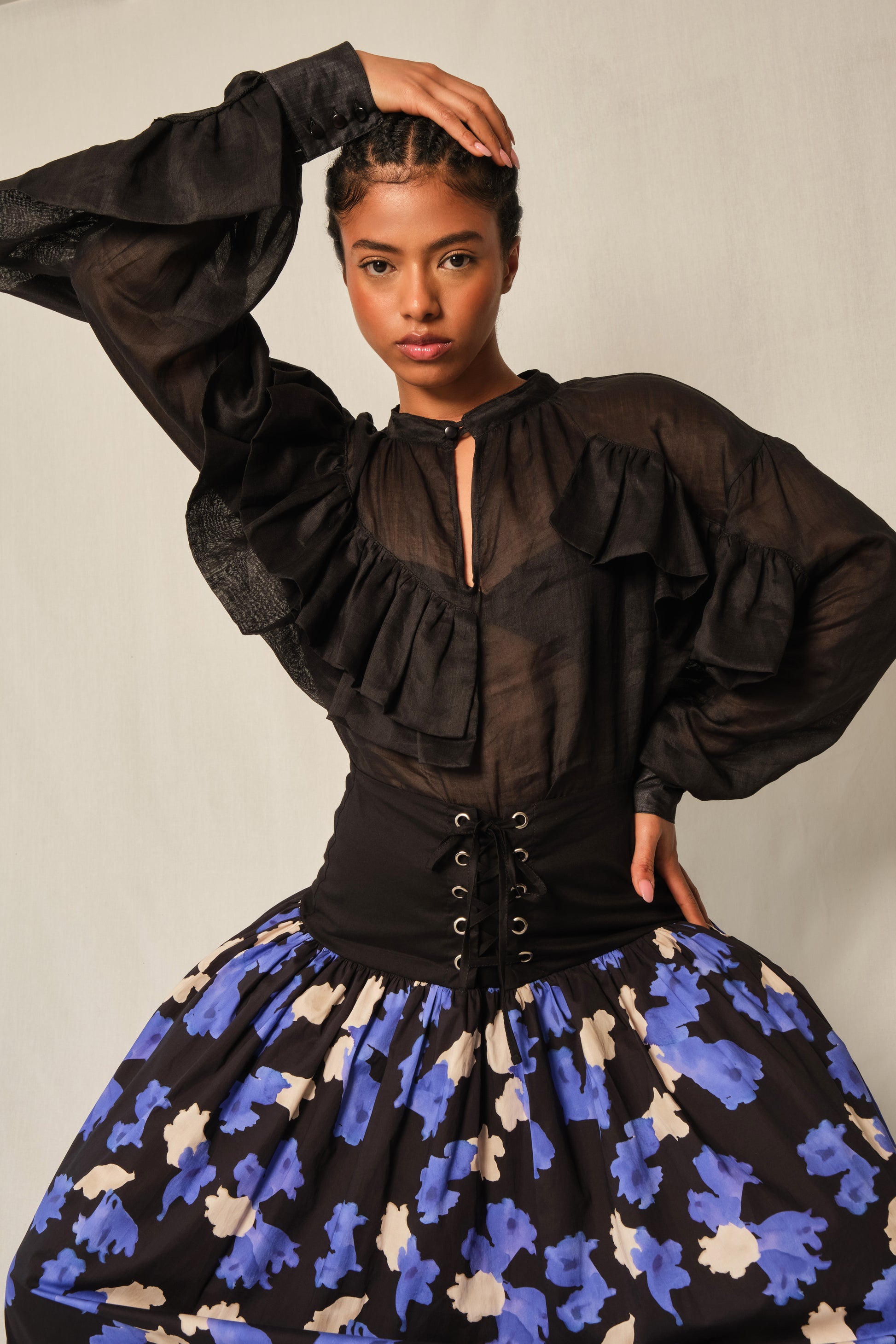 High-neck black linen ruffle blouse with keyhole button and balloon sleeves.