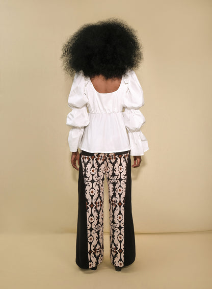 Model wearing white puff-sleeve poplin top with tie-front keyhole