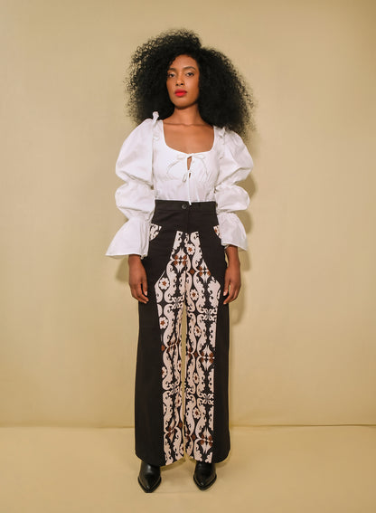 Model wearing high-waisted flared pants with maxi paisley panels