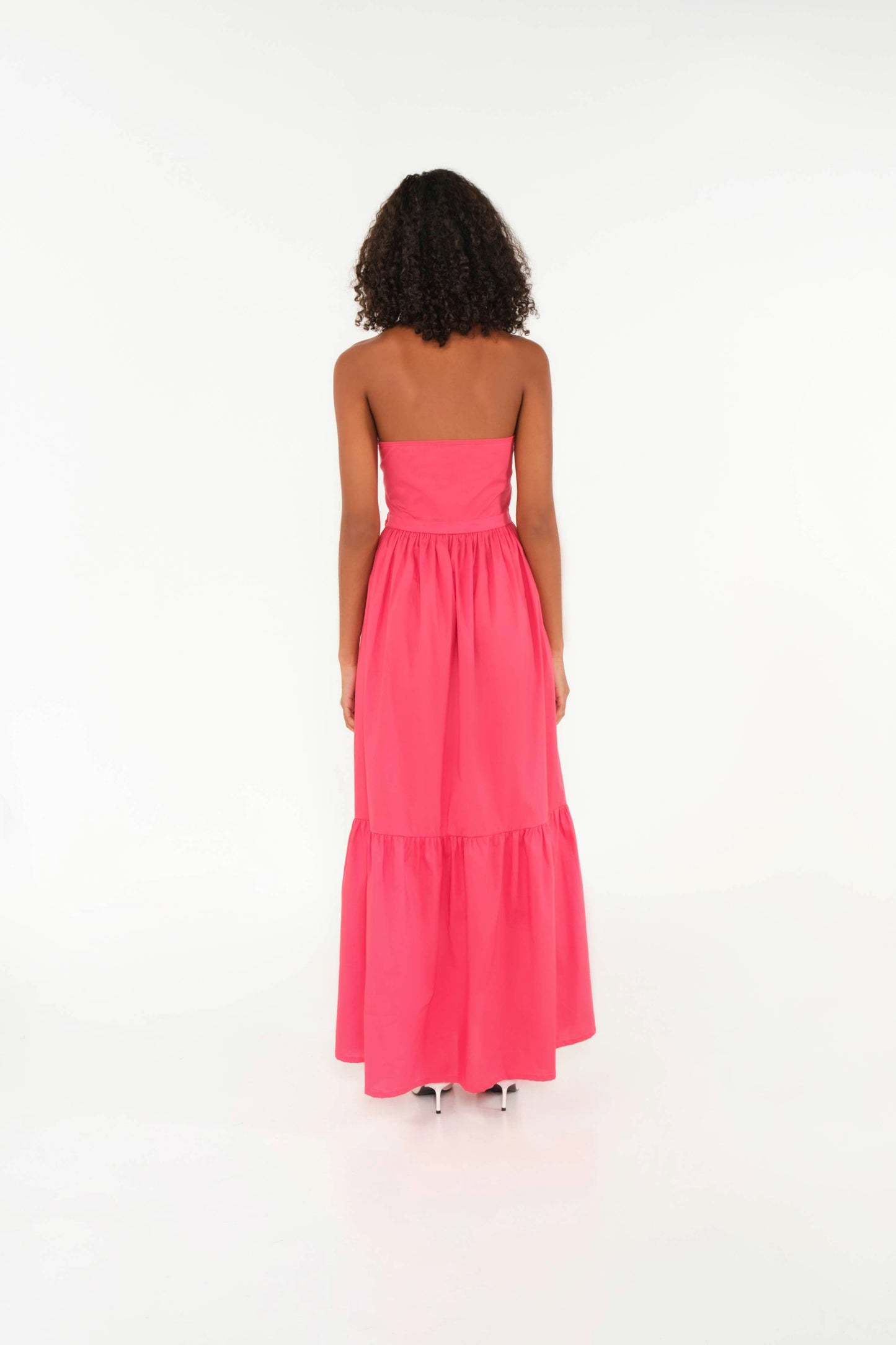Woman wearing a pink strapless dress on a white background