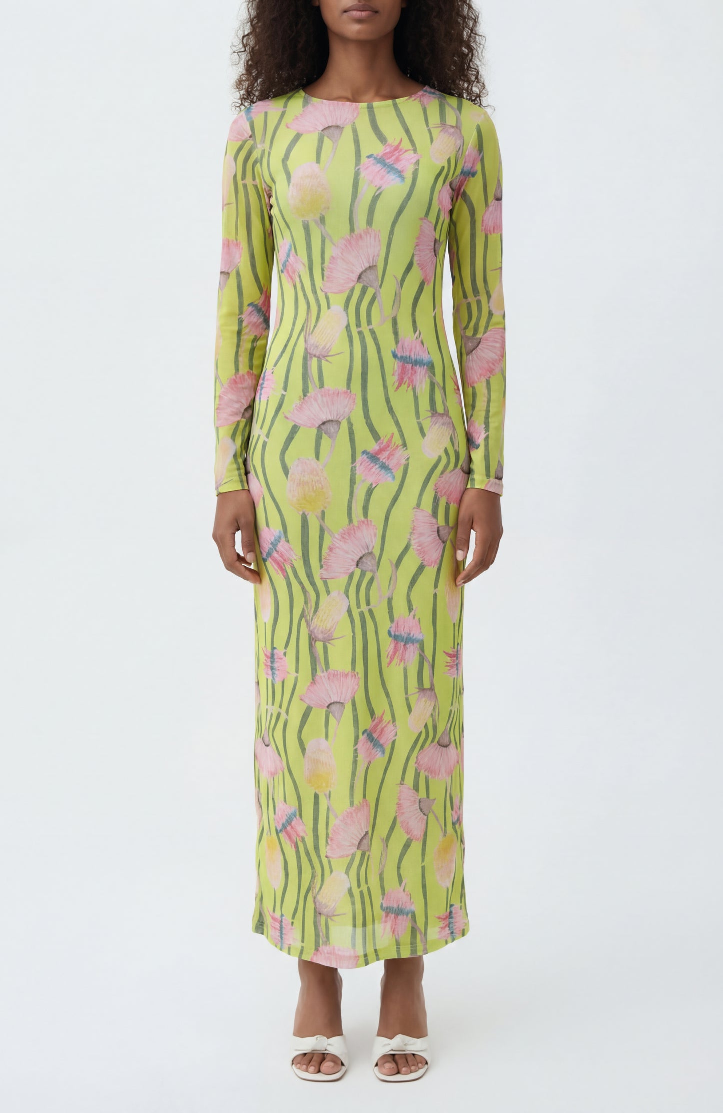 Woman wearing a long-sleeve dress with a floral pattern on a white background