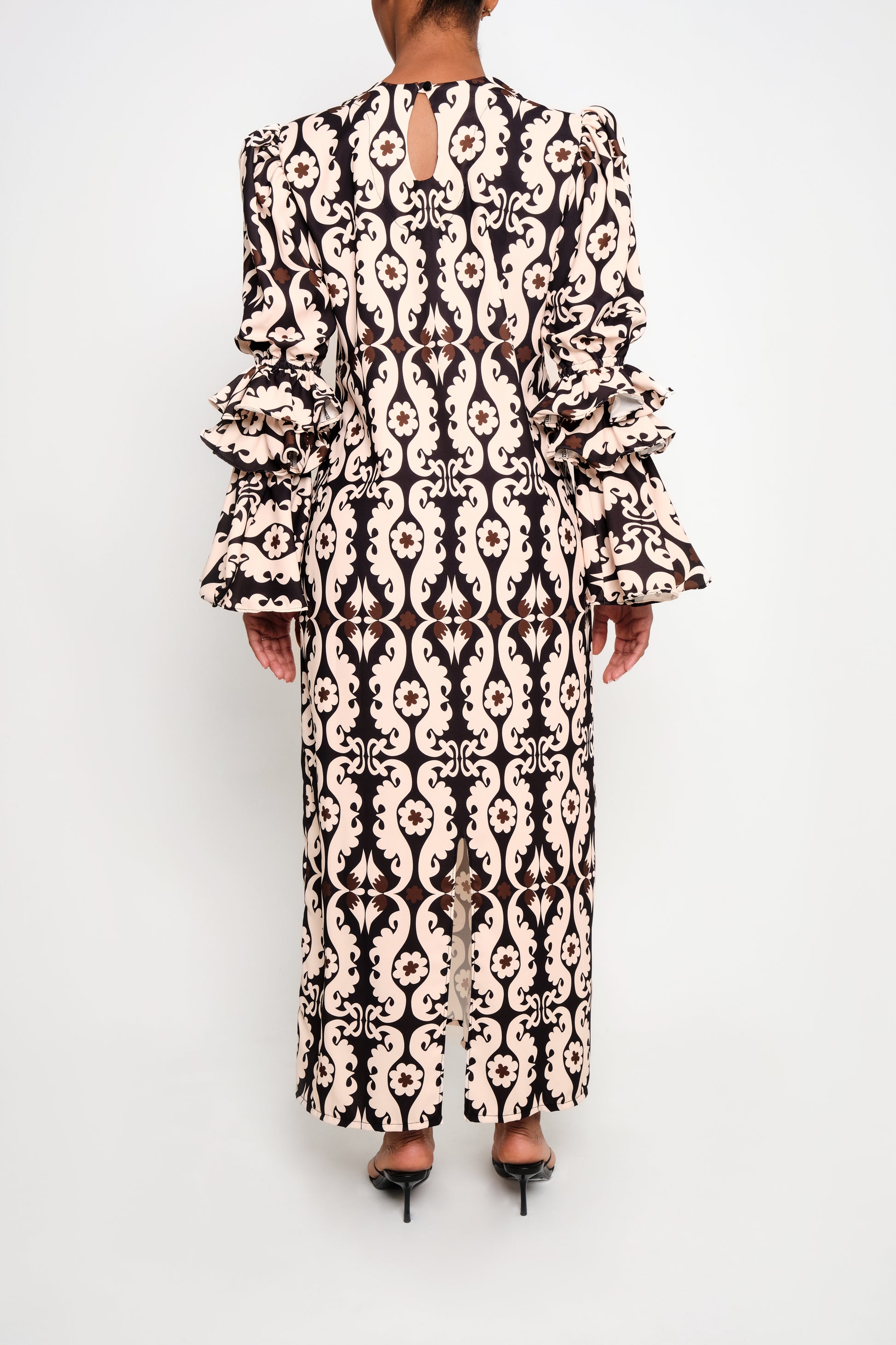A model wearing a tunic dress with ruffle sleeves back.