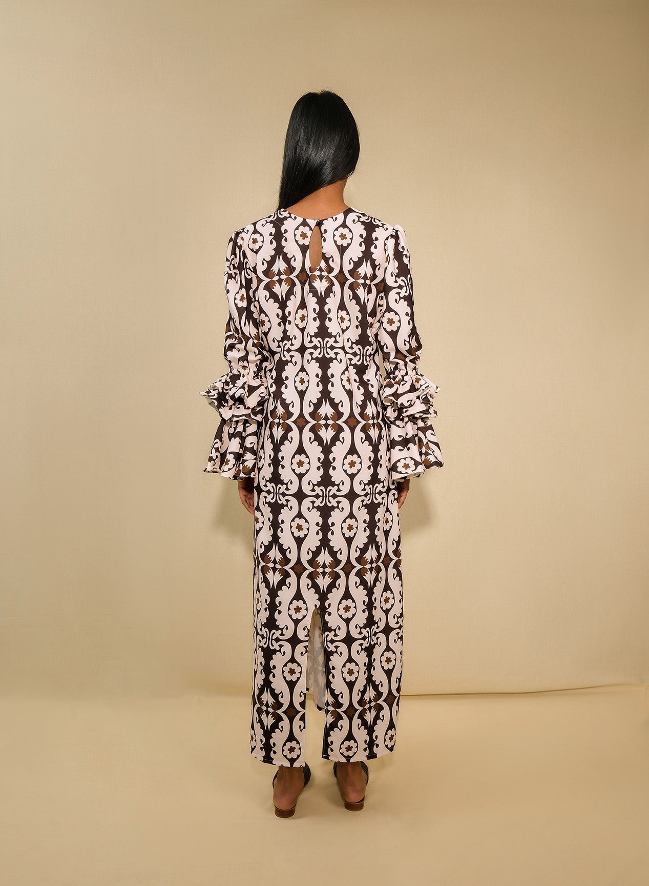 A model wearing a tunic dress with ruffles sleeves and back 