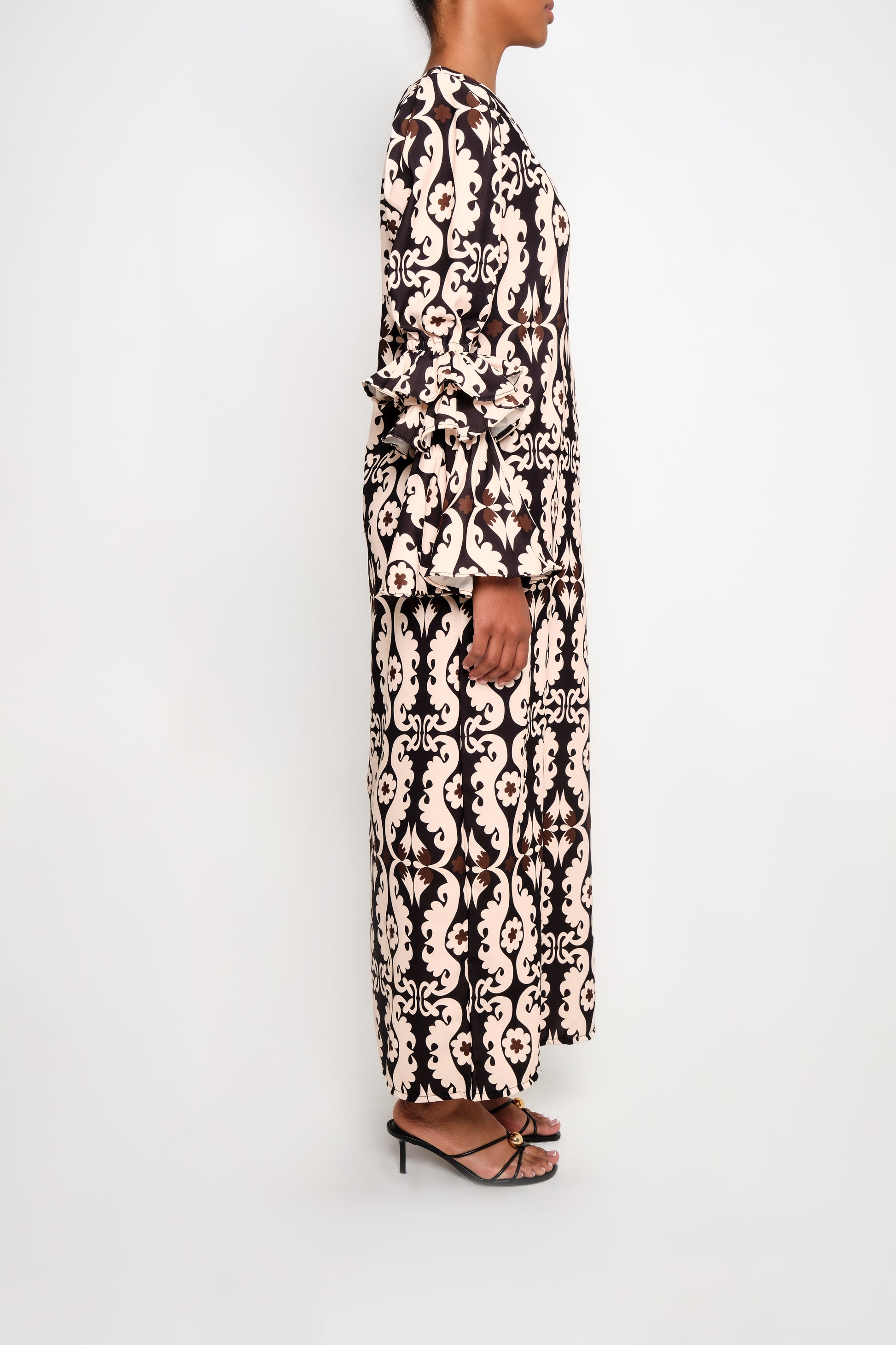 a model wearing a tunic dress ruffles sleeves on the side