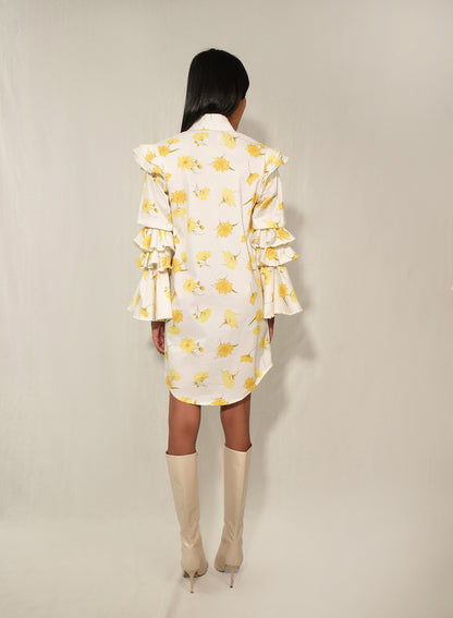Model in ruffle-sleeve floral shirt dress in yellow daisy print, mini length.