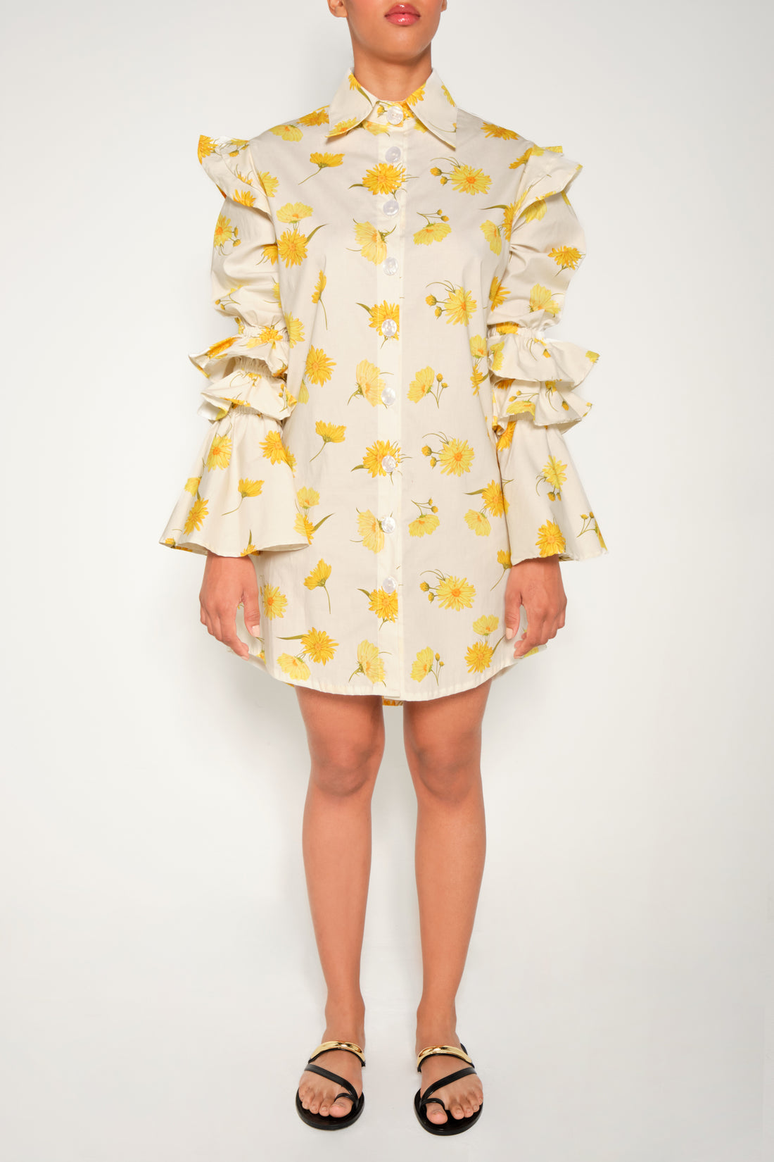 Model in ruffle-sleeve floral shirt dress in yellow daisy print, mini length.