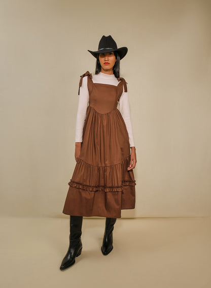Model in fit-and-flare poplin midi dress with corset bodice, adjustable ties, and tiered ruffle skirt.