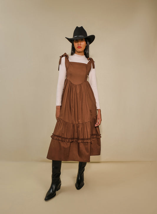 Model in fit-and-flare poplin midi dress with corset bodice, adjustable ties, and tiered ruffle skirt.