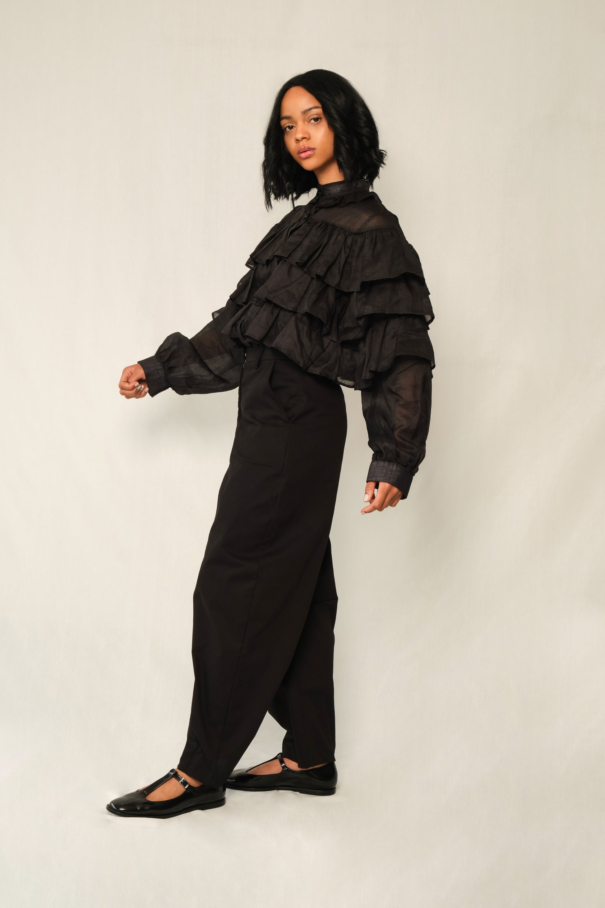 Black lightweight linen ruffle blouse with button front, tiered ruffles, and balloon sleeves.