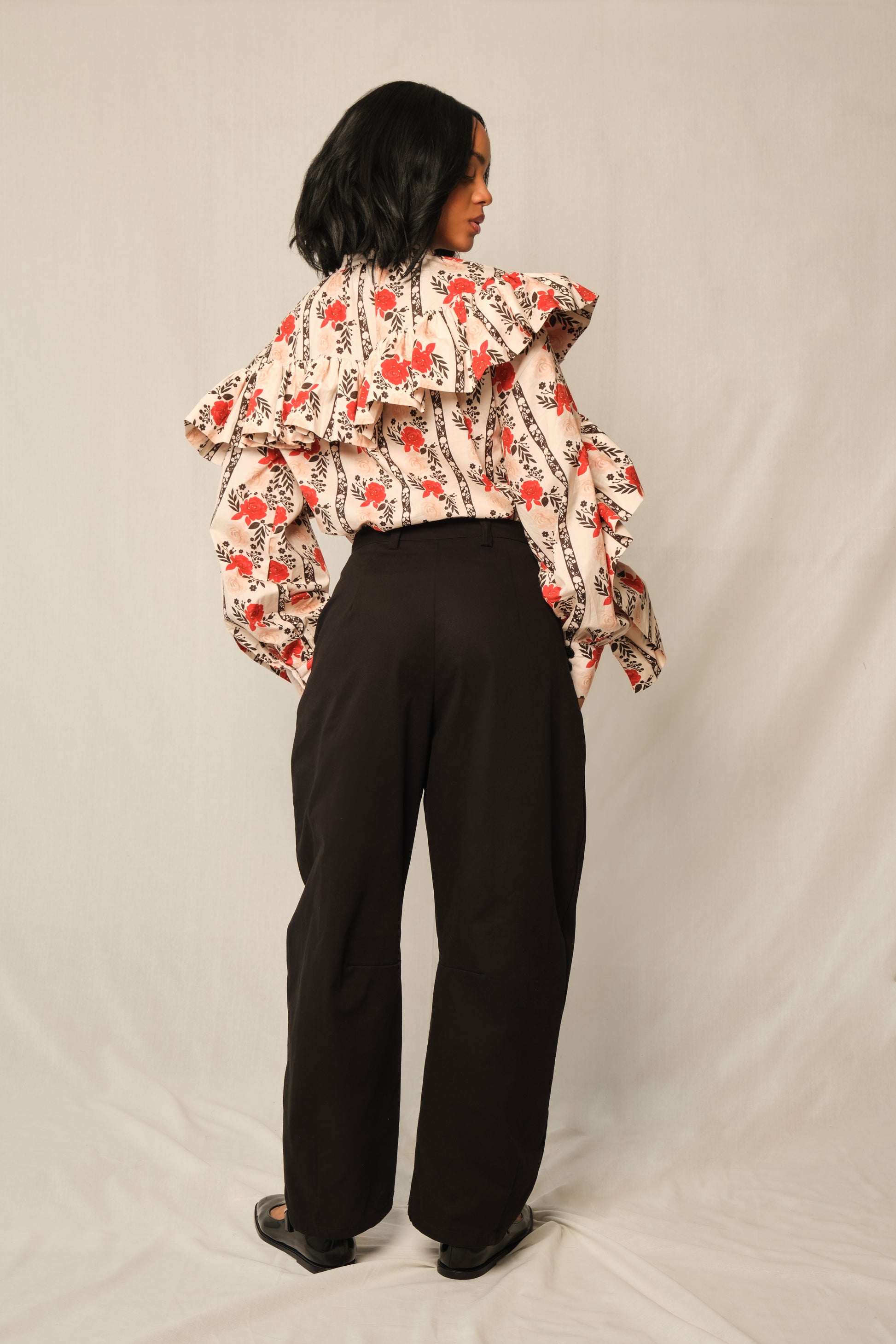 Model wearing high-waisted tapered cotton twill pants with ankle-length hem