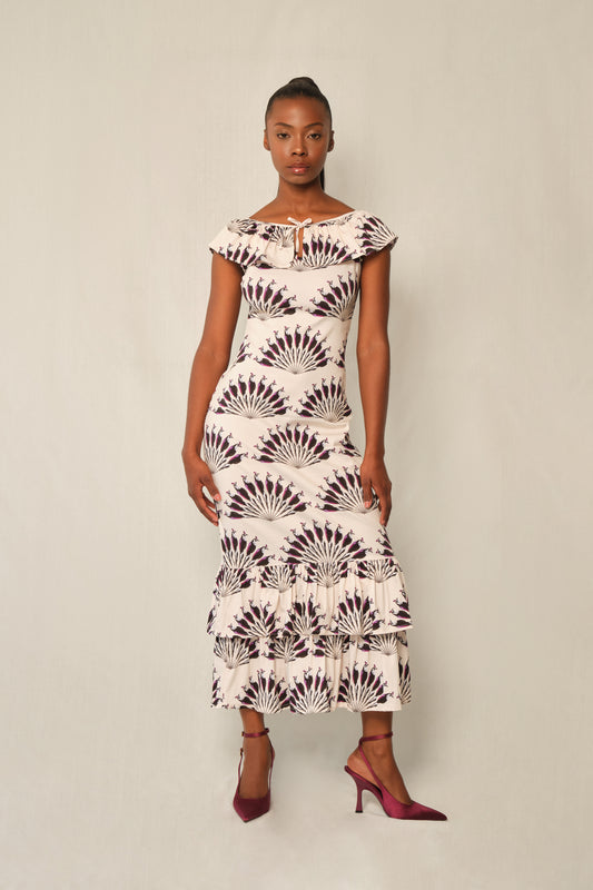 Model wearing fitted viscose midi dress in Throated Ivory print with ruffle neckline, tie keyhole, and double-tier flounce hem